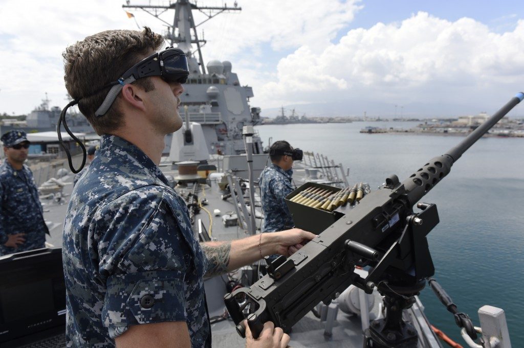 U.S. Navy using VR and AR - Sailor defending against virtual enemy combatants during a virtual reality training program demonstration.